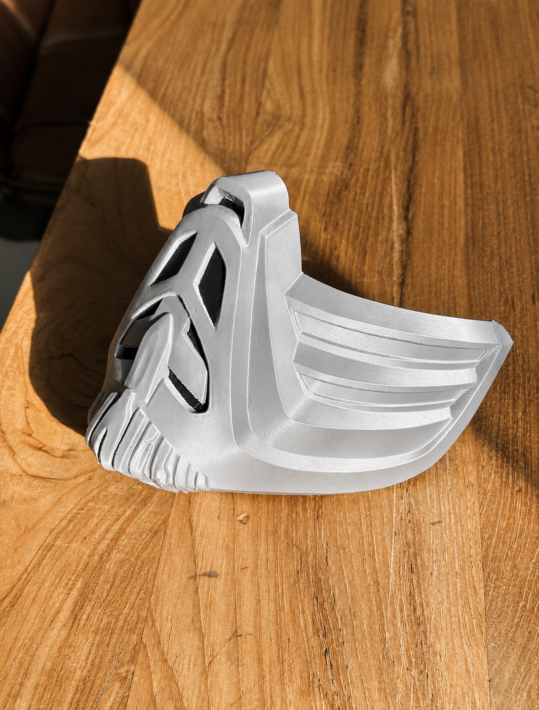 Silver FDM-printed Sub-Zero mask on a wooden surface